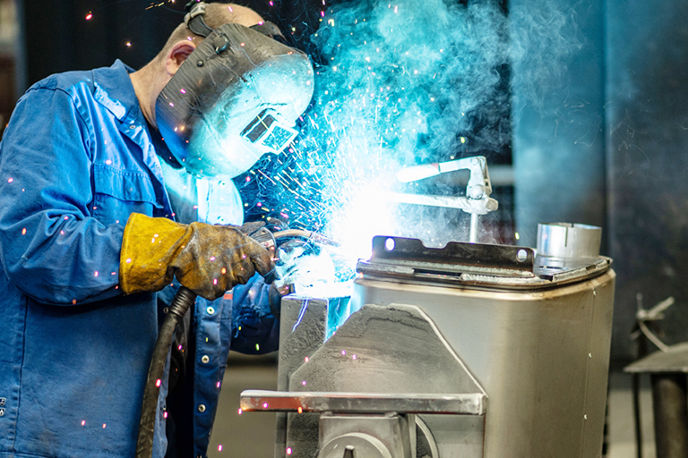Ein Mitarbeiter der RTA schweißt von Hand an einer komplexen Baugruppe. Metallbearbeitung RTA GmbH St. Aegyd, RTA Technik GmbH Lampertheim, RTA Entwicklung GmbH, Rastatt